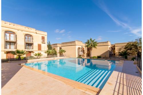 MġarrHarbour Views Gozitan Villa Shared Pool - Happy Rentals的大楼前的大型游泳池