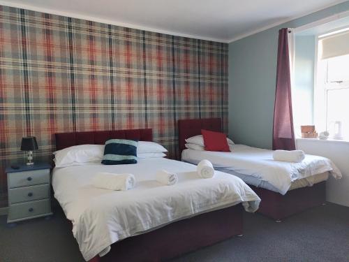 Tillicoultry布里奇旅馆的一间卧室配有两张带毛巾的床