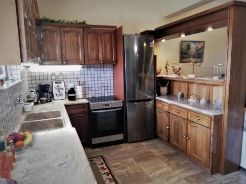 Ágios Ioánnissapfo's house的厨房配有木制橱柜和不锈钢冰箱。