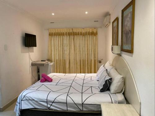 彼得马里茨堡Bogotá的卧室配有白色床和粉红色的物品