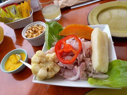 特鲁希略Bellos Dptos Huanchaco, Perú a 50 metros del mar的桌上的三明治和蔬菜等食物