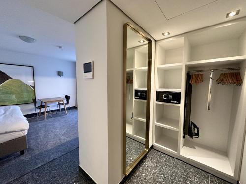 杜塞尔多夫AvidonApartments的客房设有镜子、一张床和一张书桌