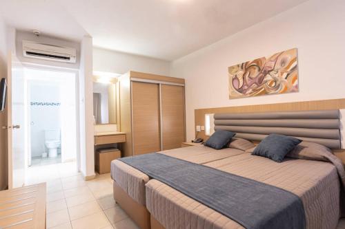 普罗塔拉斯Vrissaki Hotel Apartments的一间带大床的卧室和一间浴室
