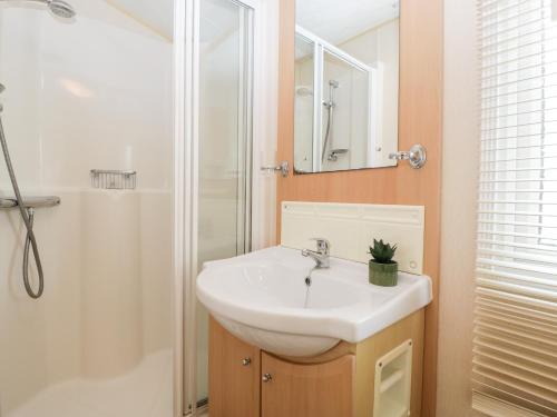 韦茅斯The Hideaway的浴室配有白色水槽和淋浴。