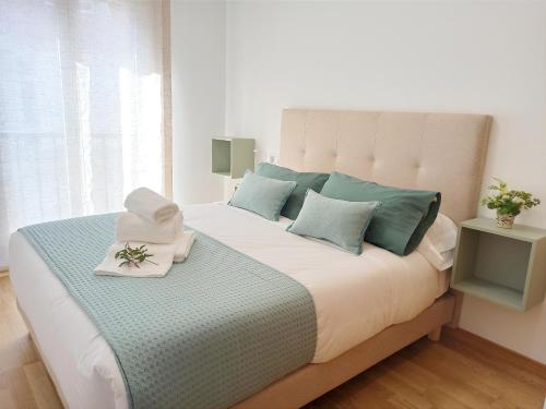 坎巴多斯Aronda Cambados apartamento céntrico的一间卧室配有一张带绿色和白色枕头的大床