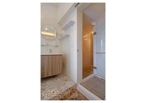 绿岛绿岛红魔鬼民宿的浴室设有步入式淋浴间,位于玻璃门旁