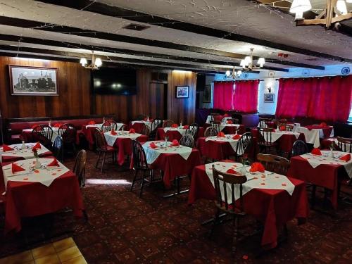 North Cornelly格林阿里克汽车酒店的一间用餐室,配有红色布艺桌椅