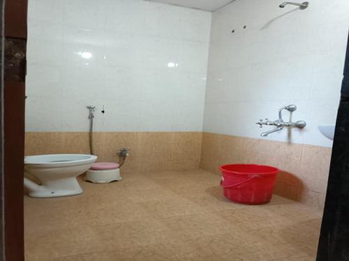 浦那Hotel Rachana Residency的一间带卫生间和红色桶的浴室