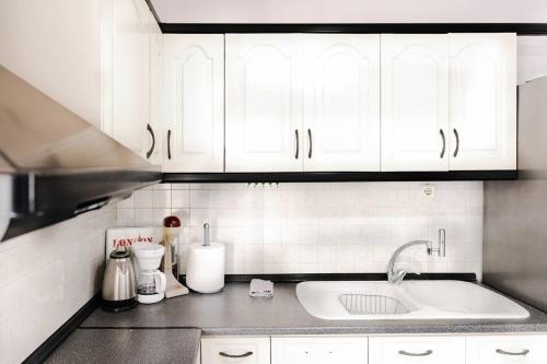 塞萨洛尼基Soleado, Nilie Hospitality MGMT的厨房配有白色橱柜和水槽