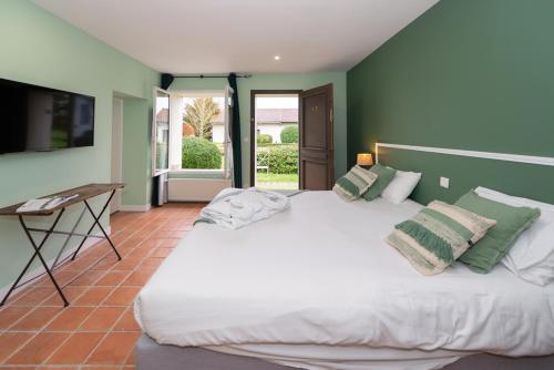 拉尚塞的伊夫乐银杏 -罗伯特艾尔桑高尔夫酒店公园的卧室配有白色大床和绿色墙壁