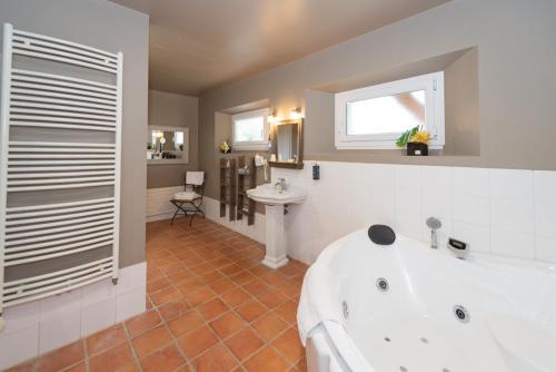 拉尚塞的伊夫乐银杏 -罗伯特艾尔桑高尔夫酒店公园的浴室配有白色浴缸和水槽