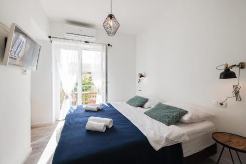 扎达尔Zaratino rooms的一间卧室配有一张大床,提供蓝色的床单和枕头