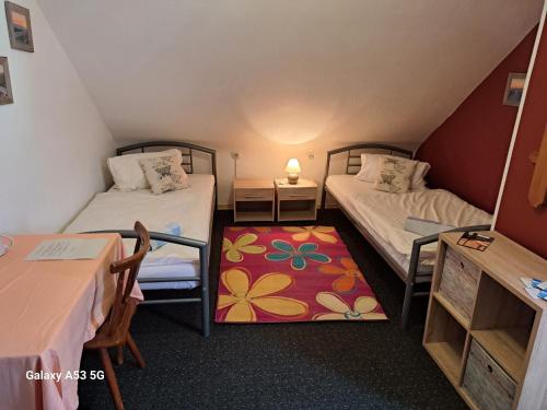 乌尔姆金索恩旅馆的小房间设有两张床和一张桌子