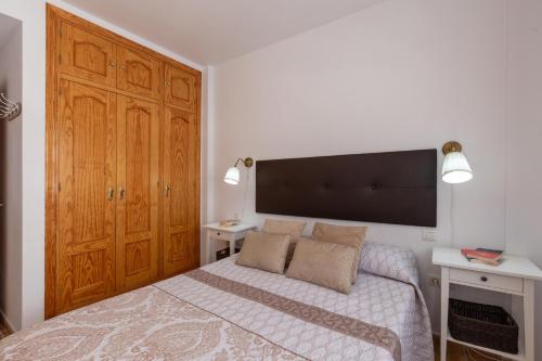 托洛克斯Tolox 2的一间卧室配有一张床和一个大型木制橱柜