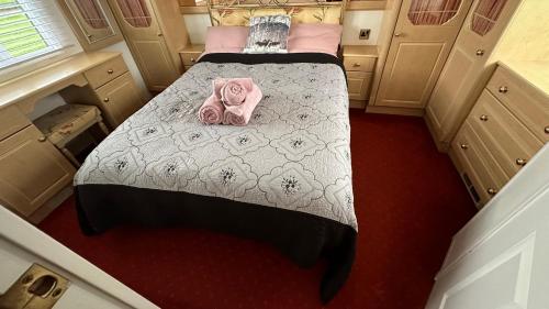 滨海克拉克顿Freedom House的一间卧室,床上有粉红色的衣服