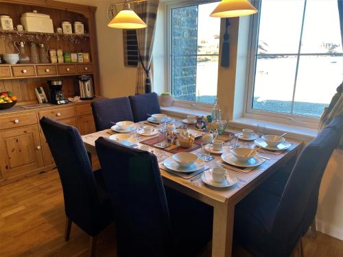 Port na LongBracadale House的一张带蓝色椅子的餐桌和一张带餐具的桌子