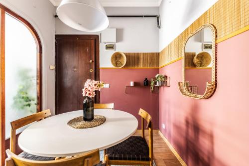伊斯坦布尔Central的一间用餐室,配有白色的桌椅和粉红色的墙壁