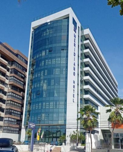 马塞约PAJUCARA FRONT BEACH 2的一座大型玻璃建筑,前面有棕榈树