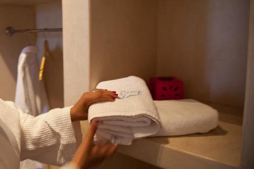 达赫拉Dakhla Camp的把毛巾堆在浴室里的女人