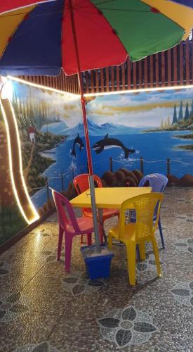 Khān YūnisFurnished apartment for families only的壁画前的桌椅和雨伞