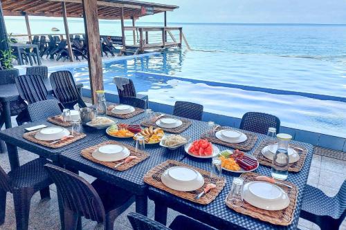 TigbaoSurigao Dream Beach Resort的水边的桌子上放着食物