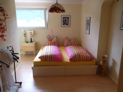ReyersvillerFewo Reyersviller的一间卧室配有带两个枕头的床和窗户