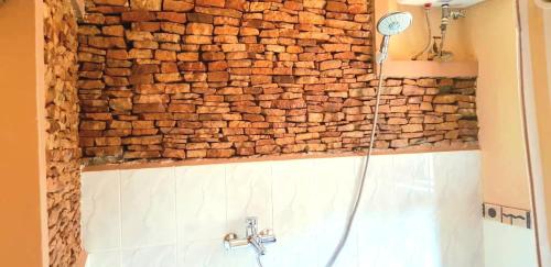 坎帕拉Keelan ace villas的浴室设有石墙,配有淋浴
