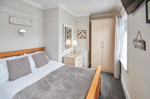 惠特比Glencoe Holiday Apartments Whitby的卧室设有一张白色大床和一扇窗户。