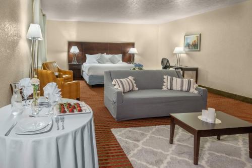 威利斯顿大威利斯顿酒店和会议中心的酒店客房配有床、沙发和桌子。