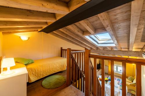 代森扎诺-德尔加达Flowers Apartments的一间带一张床的卧室,位于带木制天花板的房间内