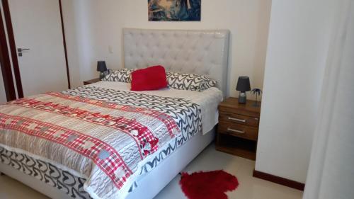 圣克鲁斯Mi casa es tu casa !的一间卧室配有一张红色枕头的床