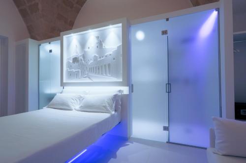 马泰拉Vittorio Veneto Matera Luxury Rooms的卧室配有一张白色床,墙上挂着一幅画