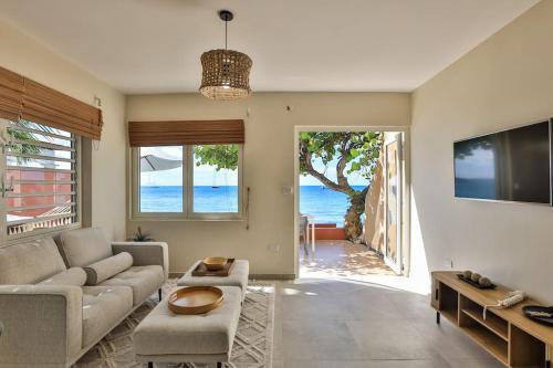 辛普森湾Hamaka condo a beachfront retreat on Simpson Bay Beach的带沙发的客厅,享有海景