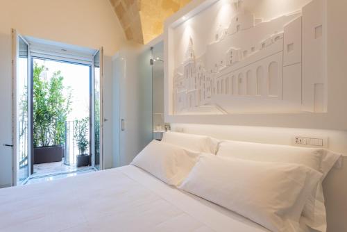 马泰拉Vittorio Veneto Matera Luxury Rooms的白色卧室配有一张带白色枕头的大床