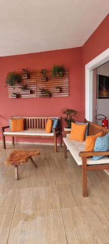 圣路易斯Pousada Litorânea的一间带长椅和红色墙壁的客厅