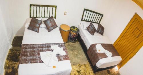 比利亚维哈Hostel Tatacoa的客房内的两张单人床