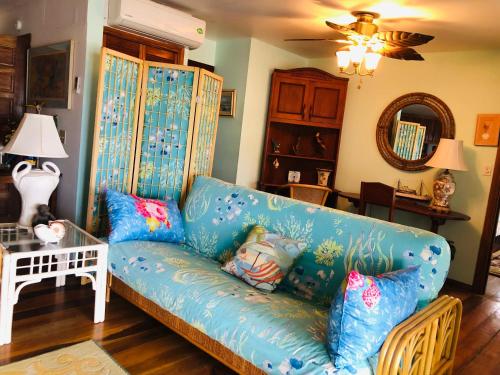 Seine Bight VillageCoral Cove Inn的客厅配有带枕头的蓝色沙发