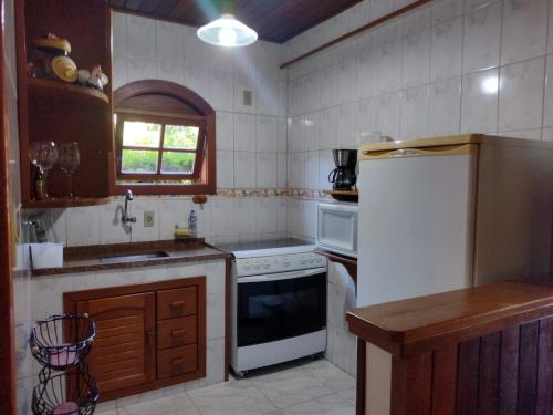 卢米亚Casa Temporada em Lumiar的厨房配有白色冰箱和水槽