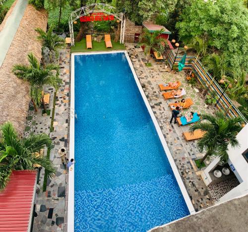宁平Elizabeth Hotel Tam Coc的享有带躺椅的大型游泳池和度假村的顶部景色