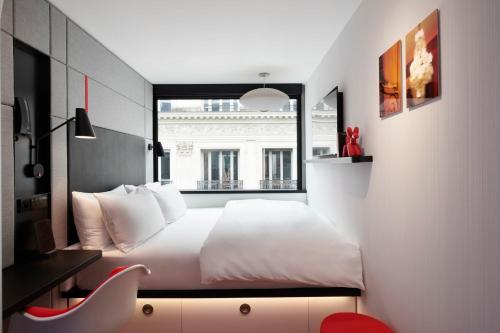 巴黎citizenM Paris Opera的卧室配有白色的床和窗户。