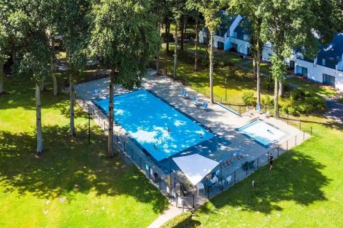 胡塔伦De Bosdreef - Hengelhoef - duplex met verwarmd openluchtzwembad的公园游泳池的顶部景色