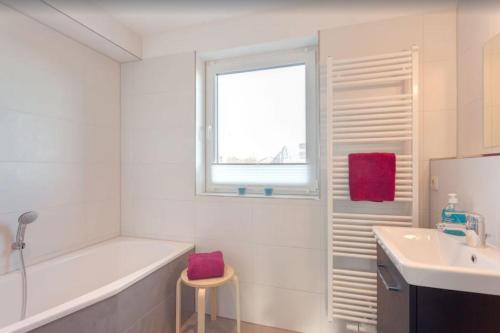 齐罗Ferienhaus Wellenreiter的白色的浴室设有浴缸和水槽。