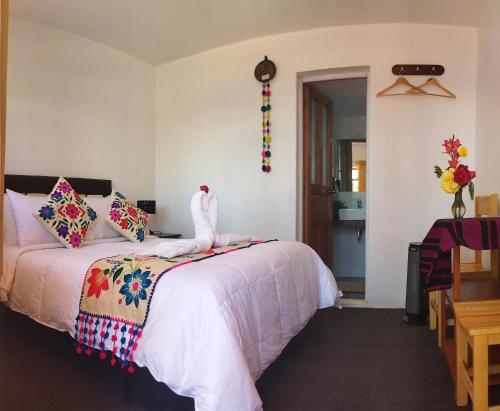 奥科苏尤Amantani Pachatata Lodge的卧室配有带白色棉被的床