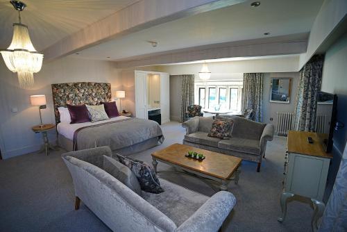 布莱克本斯坦利之家酒店的一间带一张床的客厅和一间带沙发的客厅