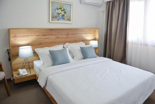 蒂瓦特Magnolia Place的卧室配有带蓝色枕头的大型白色床