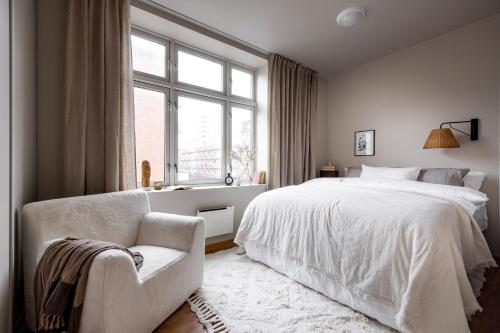 奥斯陆Hotel suite apartment的卧室配有白色的床、椅子和窗户
