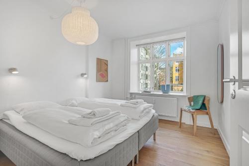 哥本哈根NABO Hotel Apartments的白色的卧室设有一张大床和一个窗户