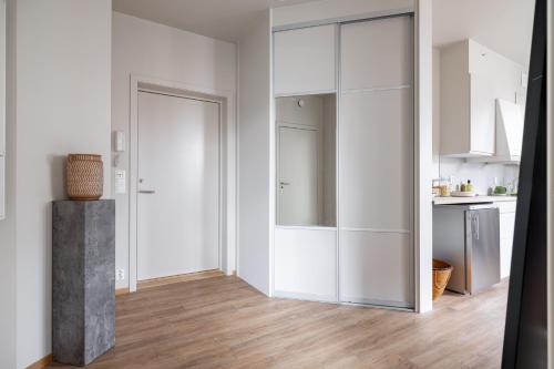 奥斯陆Hotel suite apartment的白色的厨房配有白色橱柜和木地板