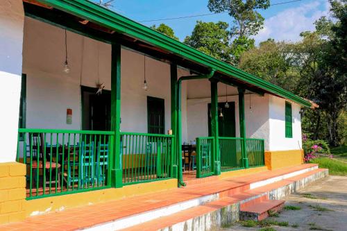 圣希尔La Hacienda的绿色和黄色的房屋,门廊