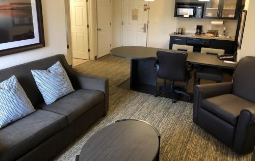 格林维尔Candlewood Suites Greenville NC, an IHG Hotel的客厅配有沙发和桌子